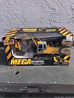 Front view of boxed New Bright Mega Excavator toy showing clear window and branding.