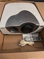 Sony LCD video projector with remote and cables in cardboard box showing overall condition and included accessories