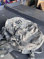 Side view of the US military backpack showing the digital camouflage pattern and 'US' lettering on top.