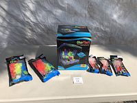 Photo showing all items included in the lot: boxed aquarium, two large decoration packages, and three packages of toy fish