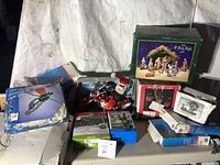 Lot contents showing boxed nativity set with multiple unopened boxes of Christmas lights and light clips. White backdrop used for display.