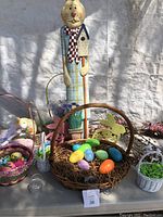 Front view of the Easter Bunny decorations lot on table, showing wooden bunny figure, baskets with colorful eggs, and bunny cutouts