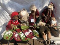 Overall lot showing four Santa figurines, one bear figurine, and six Christmas stockings.