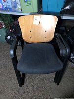 Front view of one office reception chair with wooden back and black upholstered seat, showing the structure and condition of the chair.