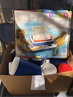 Boxed Intex Mega Chill 2 inflatable pool cooler and three reusable cups in blue, white, and red.