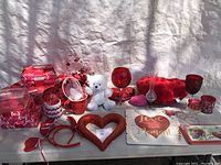 Overview of all Valentine’s Day decorations showing various items in red and pink colors including heart-shaped items, glassware, ribbons, plush teddy bear, and plaques.