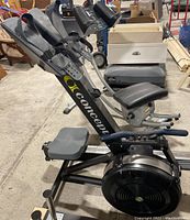 Front-right side view of Concept2 rowing machine showing sliding seat, footrests, fan housing