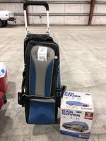 Photo of the Storm bowling bag with extended handle and front zippered compartment alongside two boxed car covers labeled 'Full Car Cover, Size 2' with vehicle images on the boxes.