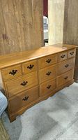 Front and side angle view of wooden dresser showing drawer arrangement and condition.