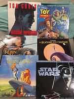 Six laserdiscs with covers including Mission Impossible, Toy Story, The Nightmare Before Christmas, Robin Hood, The Lion King, and Star Wars.