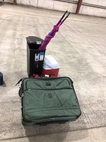 Rubbermaid cooler, green suitcase with kite and red and white cooler behind, black trash can in background