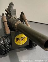 Close-up of the front of the vintage Big Bang toy cannon showing long barrel and yellow 'Big Bang 53' label.