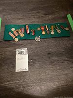 Full set of medals and badge mounted on green felt display board
