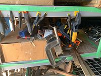 Shelf with assortment of clamps and grippers including C-clamps and spring clamps