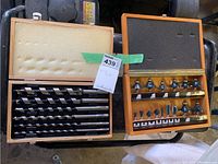 Two wooden cases, one with large auger and twist drill bits and one with various router bits with bearing guides.