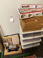 Overview of entire lot showing stacked Coverite iron boxes, woodgrain kit boxes, plastic tubs, splitter and book