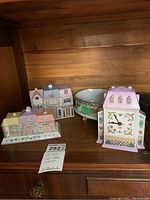 Group shot of Lenox clock, Nippon bowl, and three house-shaped containers on wooden shelf