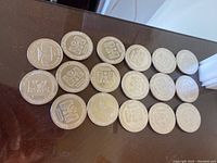 17 silver rounds arranged on table showing obverse sides