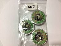 Three tins of Burt's Bees Res-Q Ointment inside a clear resealable plastic bag, showing the green round tin lids with bee illustrations and text.