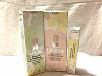 Photo showing three boxed Clinique makeup products: Beyond Perfecting Foundation + Concealer 14 Vanilla, Stay-Matte Oil-Free Makeup 19 Sand, and Just Browsing Brush-On Styling Mousse Eyebrow Tint 03 Deep Brown.