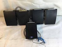 Five black HID iClass R40 contactless smart card readers arranged on a white surface. Four units are identical and one is slightly different, all connected with cables.
