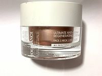 Glass jar with white lid of Jouviance Ultimate Anti-Aging Regenerating Cream showing label with usage areas and skin type suitability.
