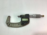 Full micrometer tool with digital readout, frame, and labeled scale visible