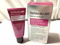 Front view of StriVectin-AR Advanced Retinol Night Treatment cream tube next to its original box showing product name and volume.