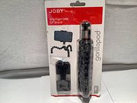 Full front view of the Joby GripTight ONE GP Stand in original packaging showing flexible tripod legs and smartphone holder.
