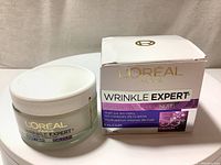 Front view of unopened moisturizer jar alongside the original box, showing branding and product name.