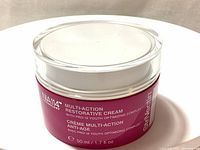 Full top and side view of the NIA 114 Multi-Action Restorative Cream jar, showing label and lid design.