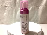 Front view of NIA-114 Wash + Glow Hydrating Cleansing Foam bottle with label visible.