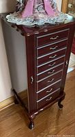 Closed armoire showing overall mahogany finish, eight drawers and curved cabriole legs