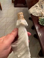 Front view of the Royal Doulton Loving You figurine showing the woman in a long white dress holding a dove.
