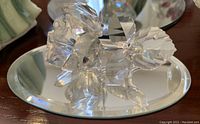Clear Swarovski crystal rose with detailed petals and leaves viewed from side