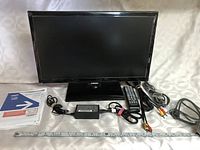 21 inch Samsung television model UN22F5000 with accessories and manuals arranged in front and beside it.