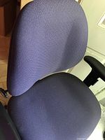 Front and angled view of Allseating Corporation office chair showing purple-grey fabric seat and back, black adjustable armrest, and black frame with five wheels.