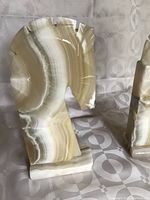 Front and side views of the pair of onyx horse head bookends, showing the banded cream and taupe striped natural onyx with carved horse head profiles.