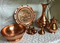 Full set of copper items arranged on fabric including platter, tall pitcher, tea/coffee pot, fruit bowl, small pitcher, and miniature set