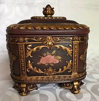Rectangular bronze and gold decorative box with floral accents and lid