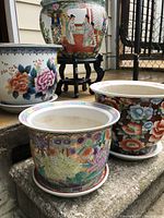 Four planters grouped together on stone step showing variety of colors and styles