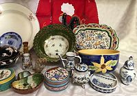 Various hand-painted pottery bowls, plates, covered butter/cheese dish, small coasters, and small figurine salt and pepper shakers along with stainless steel oil and vinegar dispensers.