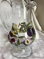Close-up of the sangria pitcher showing painted cherries and plums near the base.
