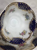 Close-up image showing Isabella pattern saucer with cobalt blue sections decorated with floral motifs and gold lattice accents.