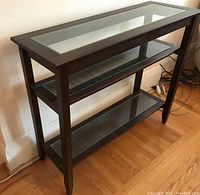 Full view of the dark wood shelf unit showing three glass-covered shelves with bamboo-style slats underneath.