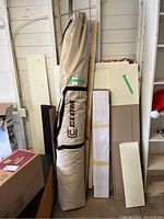 Beige zippered canvas bag standing upright against wall