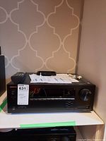 Full front view of Onkyo receiver with accessories on top