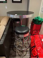 Photo showing two matching black and chrome stools in front of the table