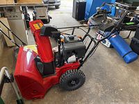 Side view showing entire snowblower assembly including auger housing, engine, and controls