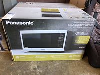 Front of unopened Panasonic microwave oven box showing brand name and oven depiction